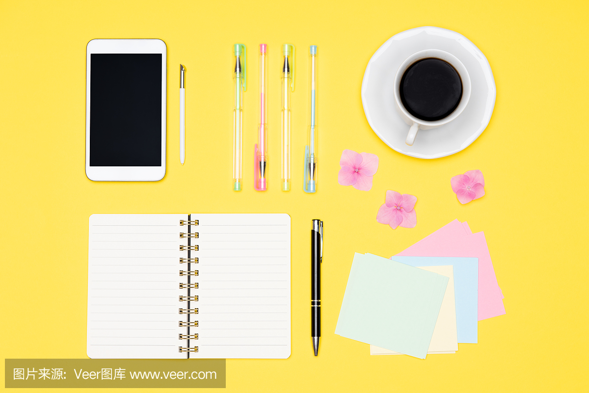 学生书桌平放。俯视图的工作空间桌子与早上的咖啡,智能手机和文具,办公用品在柔和的黄色背景。回到学校。